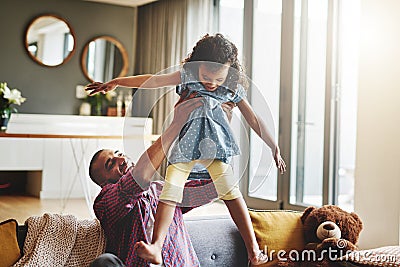 Its playtime between father and daughter. an affectionate young father lifting his daughter playfully in their living Stock Photo