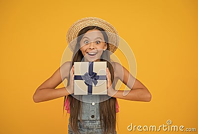 Its time for surprise. Happy girl hold gift yellow background. Surprise box. Surprised look of little child. Birthday Stock Photo