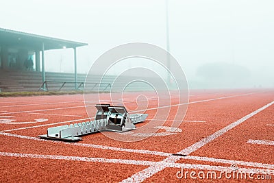 Its time to put your foot down. metal starting blocks standing out on a running track. Stock Photo