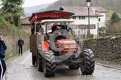 Tractor drawn by a tractor and transporting women dressed as sevillanas in the rural carnival parade. Editorial Stock Photo