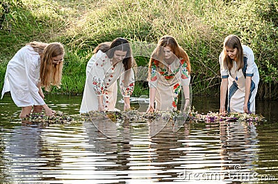 Ivano-Frankivsk, Ukraine July 20, 2023: girls stand in the water, joke and follow wreaths in the water. Editorial Stock Photo