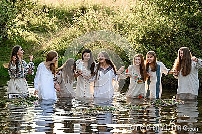 Ivano-Frankivsk, Ukraine July 20, 2023: girls stand in the water, joke and follow wreaths in the water. Editorial Stock Photo