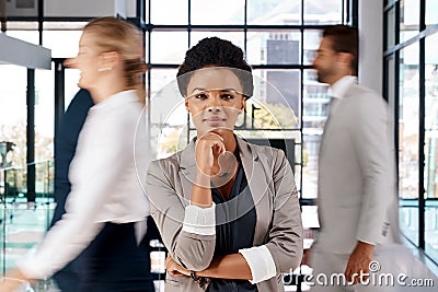 Ive always been determined to standout amongst the crowd. Portrait of a young businesswoman standing in a busy office. Stock Photo