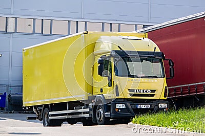 Iveco EuroCargo 180E25 yellow truck in front of depot Editorial Stock Photo