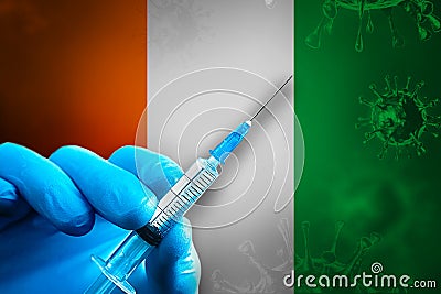 Ivory-Coast Covid-19 Vaccination Campaign. Hand in a blue rubber glove holds a syringe with covid-19 virus vaccine in Stock Photo