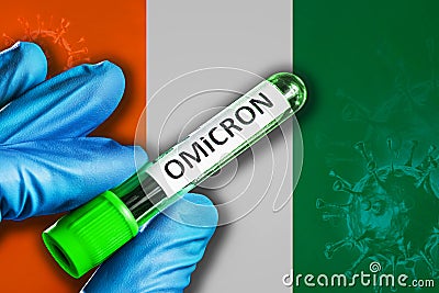 Ivory-Coast outbreak of omicron variant. Hand holds a test tube with covid-19 virus omicron in front of Ivory-Coast flag Stock Photo