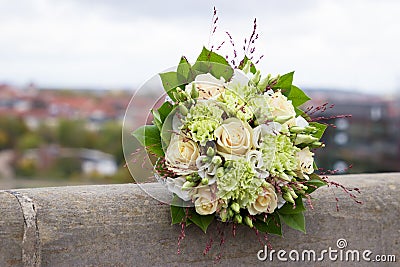 Ivory and green wedding bouquet of roses and carnation flowers on the city background Stock Photo