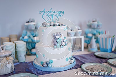 Birthday cake for a one year old boy. Teddy bear cartoon character shape and blue decorations of mastic. Candy bar. Editorial Stock Photo