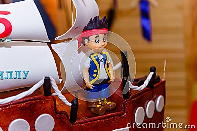 Boy birthday cake in shape of sea ship with captain mastic figure. Editorial Stock Photo