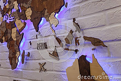 Wooden decorative world map with purple neon backlight on apartment wall. Modern interior design. Editorial Stock Photo