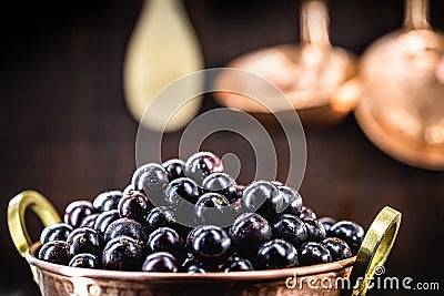 Jaboticaba or jabuticaba, Brazilian and South American fruit, in a copper pot on a rustic table. Fruit for medicinal and culinary Stock Photo