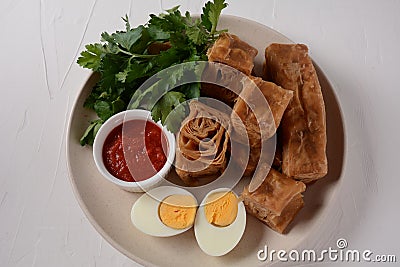 Jachnun or Jahnun, Yemenite Jewish pastry, served with fresh grated tomato and boiled egg and Zhug, Stock Photo