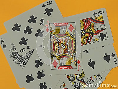 The Jack of Diamonds playing card is placed above other playing cards of different suits on a yellow background. Stock Photo