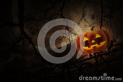 Jack O Lantern pumpkin on old fence over dead tree, moon and clo Stock Photo