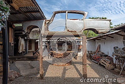 Jacked up rusty wrecked car in a backyard in Livingstone, Zambia Editorial Stock Photo