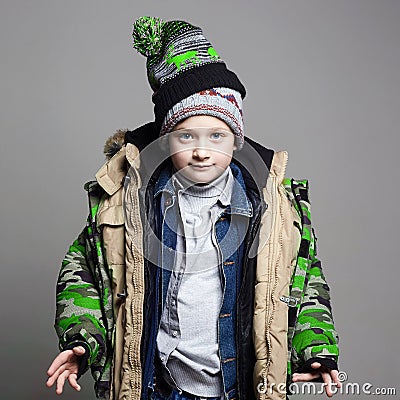 5 jackets is dressed on the Kid. Funny Boy in winter outerwear Stock Photo