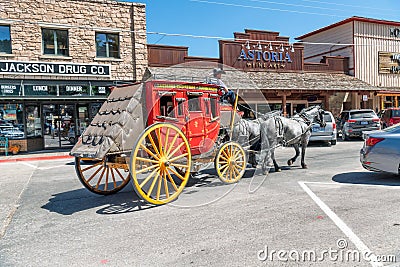 JACKSON HOLE, WY - JULY 11, 2019: Colorful horse carriage with tourists in the town. Jackson is a famous tourist destination Editorial Stock Photo