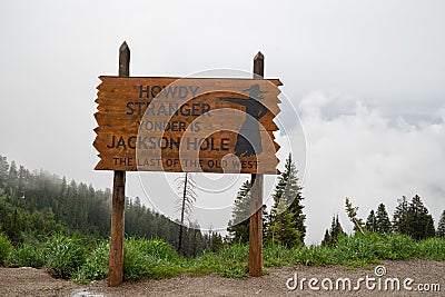 Jackson, Wyoming - June 25, 2020: Welcome sign for Jackson Hole area, Howdy Strangers - foggy, overcast day on Teton Pass Editorial Stock Photo
