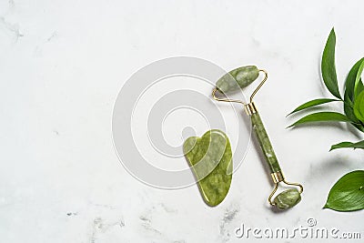 Jade roller and gua sha stone massager for face. Stock Photo