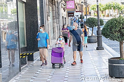 Jaen, Spain - June 18, 2020: People walking by the city wearing protective or medical face masks during the new normal due to Editorial Stock Photo