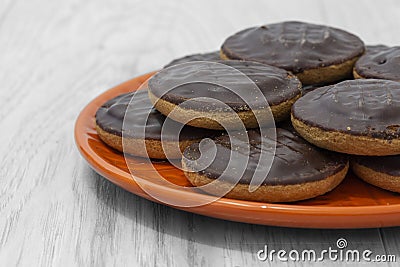 Jaffa cakes biscuits stacked on an orange plate. Stock Photo