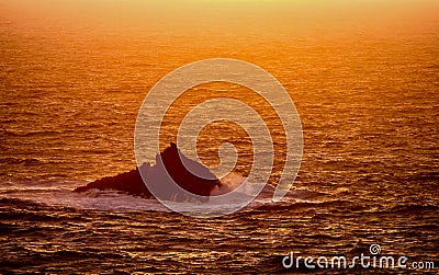 Jagged rocks along the coast with waves crushing on Stock Photo