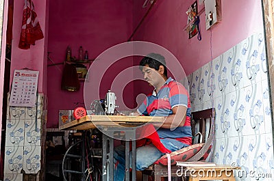 Middle age tailor sewing at his shop Editorial Stock Photo