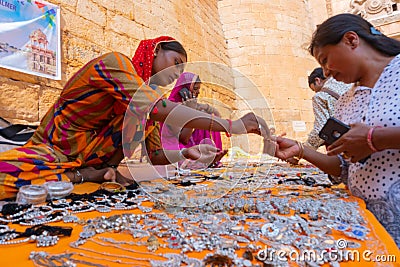 Jaisalmer, Rajasthan, India - October 13, 2019 : Rajasthani women selling and negotiating price of jewelleries with female tourist Editorial Stock Photo