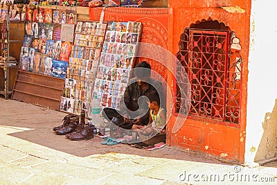 Shoemaker with his child setting at the street of Jaisalmer Editorial Stock Photo