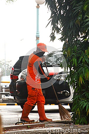 Jakarta, indonesia street broom workers as team orange Editorial Stock Photo