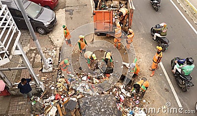 Jakarta, jakarta / indonesia - january 4th 2020: The janitor cleaning and transporting the rubbish left over by the flood disaste Editorial Stock Photo