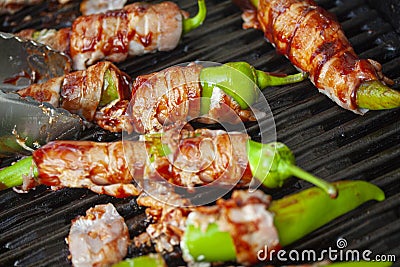 Jalapeno poppers on burning, grill. Spicy peppers stuffed with cream cheese and wrapped in bacon. Stock Photo