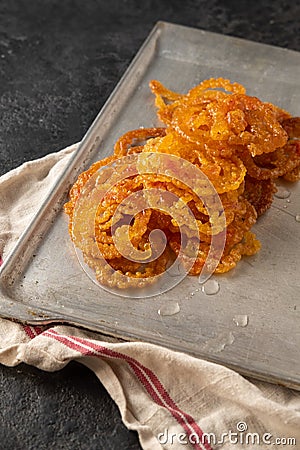 Jalebi Indian sweets on a metal tray on a dark background. Stock Photo