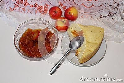 Jam from yellow-red apples and cake. Next are fruits and spoon. Stock Photo