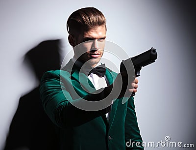 James Bond wannabe young assasin pointing his big pistol Stock Photo