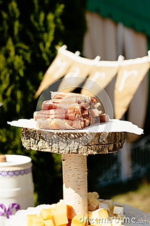 Jamon meat rol with chess on served wooden board Stock Photo