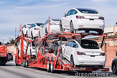 Jan 18, 2020 Palo Alto / CA / USA - Car transporter carries Tesla Model 3 new vehicles on a freeway in San Francisco bay area, Editorial Stock Photo