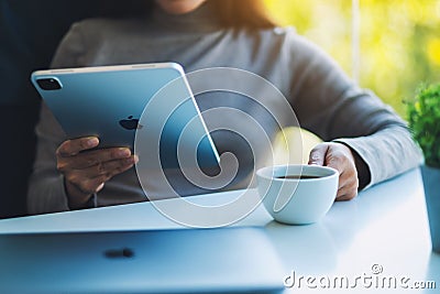 Jan 5th 2021 : A woman using Apple New Ipad Pro 2020 digital tablet with Apple MacBook Pro laptop computer while Editorial Stock Photo