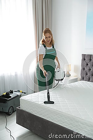 Janitor cleaning mattress with professional equipment Stock Photo