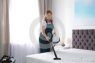 Janitor cleaning mattress with professional equipment Stock Photo