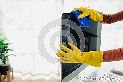 Janitor cleaning the office, Clean the monitor with a rag, wear gloves and wipe with a towel, Wear rubber gloves when working with Stock Photo