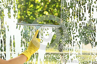 Janitor cleaning window with squeegee indoors Stock Photo