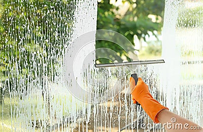 Janitor cleaning window with squeegee indoors Stock Photo