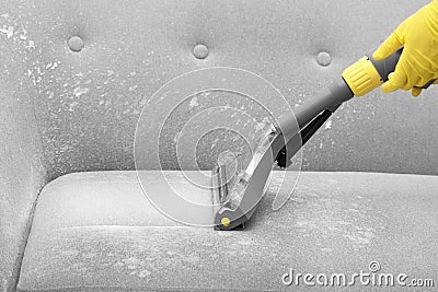 Janitor removing dirt from sofa with upholstery cleane Stock Photo