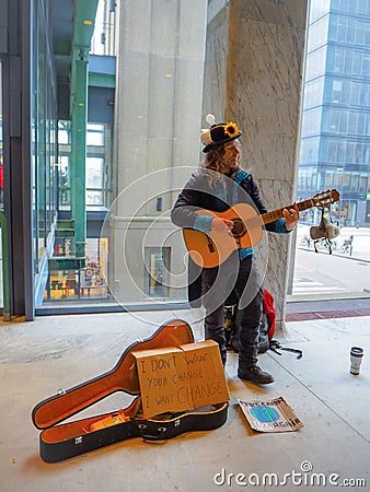 Male street artist playing guitar during a climate change protest rally as a call to action Editorial Stock Photo