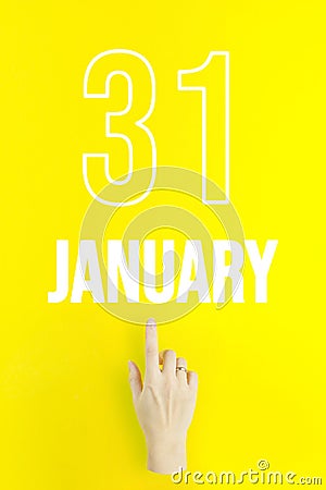 January 31st . Day 31 of month, Calendar date.Hand finger pointing at a calendar date on yellow background.Winter month, day of Stock Photo