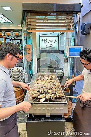 Japan. Miyajima. Hiroshima. Grilling oysters in a restaurant Editorial Stock Photo