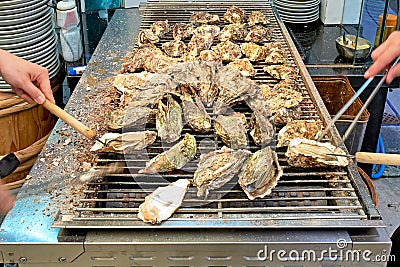 Japan. Miyajima. Hiroshima. Grilling oysters in a restaurant Stock Photo