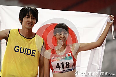 Japan`s Uran Sawada 706 and her guide Shiokawa Ryuhei celebrate Asian Para Games 2018 Editorial Stock Photo