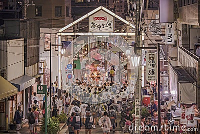 Japanese bear Shinto shrine mikoshi on their shoulders during the Obon festival in the retro old-fashionned shopping street Yanaka Editorial Stock Photo